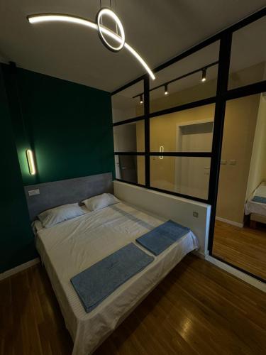 a bedroom with a bed with a green wall at Gigi Apartment by eluxory in Skopje