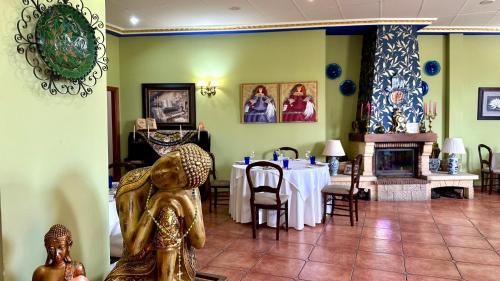 a dining room with a table and a fireplace at Hotel El Curro in Burunchel