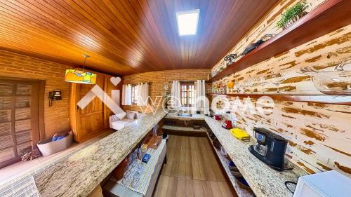 a room with a wooden wall with a long counter at Chale aconchegante em Sao Bento do Sapucai in São Bento do Sapucaí