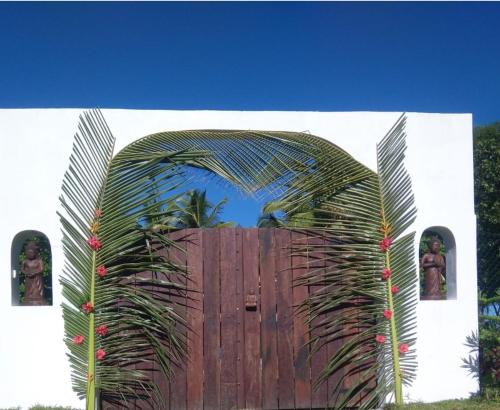 an archway with a wooden fence and a wooden door at La VILLA BORAHA 300m2 PROPRIÉTÉ ENTIERE en bord de plage PISCINE PRIVEE Cuisine TV Wifi in Sainte Marie
