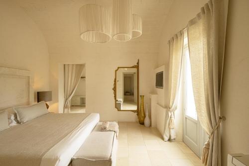 a bedroom with a bed and a mirror and a window at Masseria San Francesco in Savelletri di Fasano