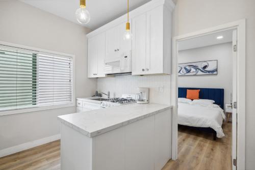 a kitchen with white cabinets and a bed in a room at West Oceanfront Oasis 4 in Newport Beach