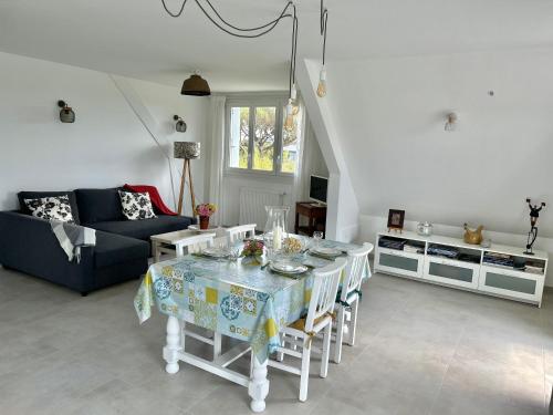 a living room with a table and a couch at Appartement près de la mer in Larmor-Plage