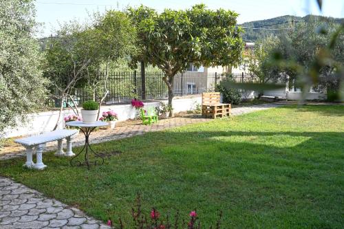 a garden with a bench and a table in the grass at "Kochili Villa" LUXURY VILLA in Áyios Andréas