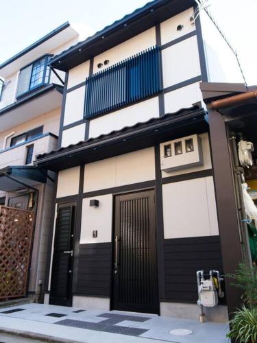 a building with black and white doors on a street at Miyanonoki Toji Kyoto in Kyoto