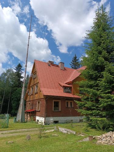 a large wooden house with a red roof at Strażnica Pod Lasem in Lasowka