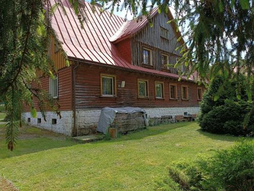 a large wooden house with a red roof at Strażnica Pod Lasem in Lasowka