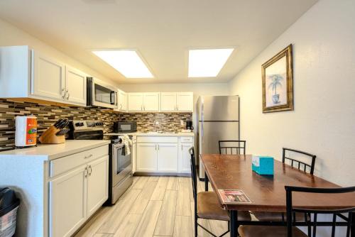 サウス・パドレ・アイランドにあるPelicans Perch Charming 1BR Near Beach with Patio 160のキッチン(白いキャビネット、テーブル、冷蔵庫付)