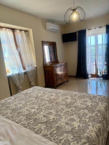 a bedroom with a bed and a dresser and windows at La Cupoletta Holiday House -Magnolia in Trevignano Romano