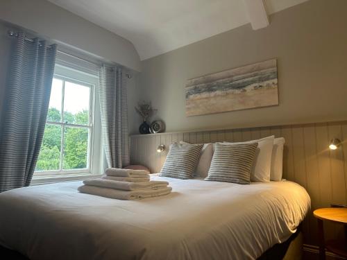 a bedroom with a bed with towels on it at Kings Head Coltishall in Norwich