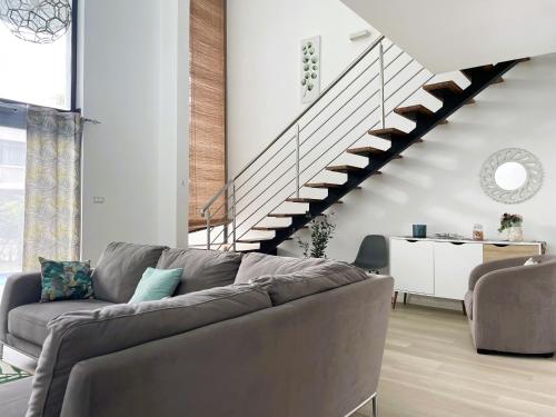 a living room with a couch and a staircase at SG5 l Le Turquoise - second line Beachfront in Cap Malheureux