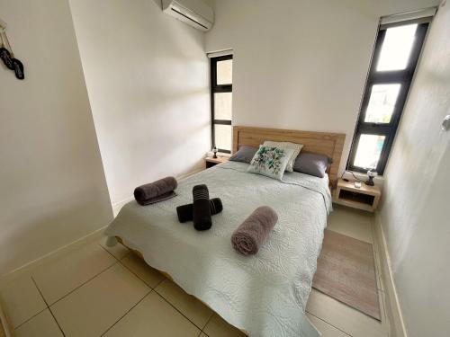 a bedroom with a bed with towels on it at SG5 l Le Turquoise - second line Beachfront in Cap Malheureux