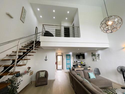 a living room with a couch and a staircase at SG5 l Le Turquoise - second line Beachfront in Cap Malheureux