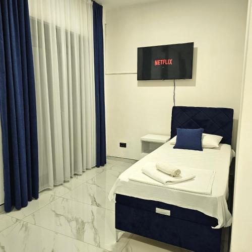 a bedroom with a bed and a tv on the wall at Nejla Apartmani Stoj in Ulcinj