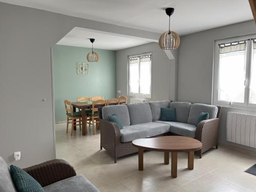 a living room with a couch and a table at Le Charles Pierre in La Ferté-Saint-Aubin