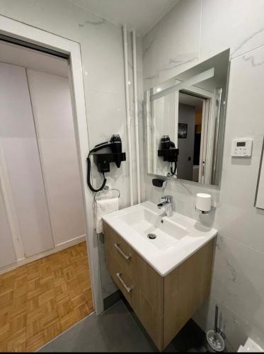 une salle de bain avec un lavabo et un miroir dans l'établissement PARIS Esplanade 1029, à Courbevoie