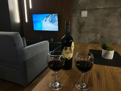 a bottle of wine and two glasses on a table at Central studio apartment in Mojkovac