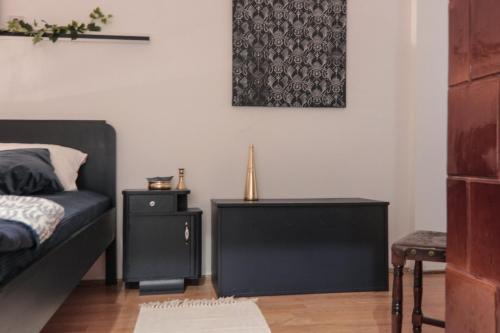 a bedroom with a black bed and a night stand at Apartmani Komoč in Novi Bečej