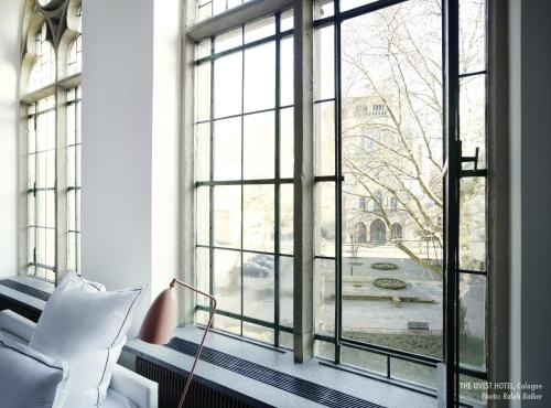 a living room with a window looking out at a courtyard at THE QVEST hideaway in Cologne