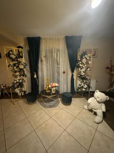 a living room with a teddy bear and a table at Pensiunea Floarea Munților in Moieciu de Sus