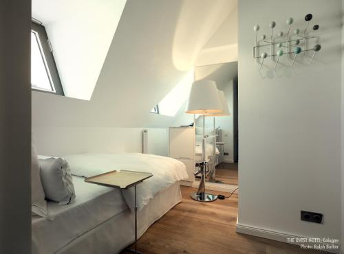 a bedroom with a bed and a lamp and a table at THE QVEST hideaway in Cologne
