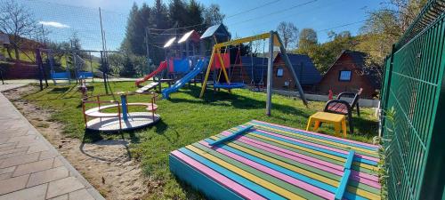 a park with a playground with slides and swings at WILLA NA WYŁĄCZNOŚĆ 12 os BIESZCZADY z Salą Imprezową, Jacuzzi, Sauną, Balią Zewnętrzną oraz 2 baseny z podgrzewaną wodą - Rezydencja Matiaszówka in Polańczyk