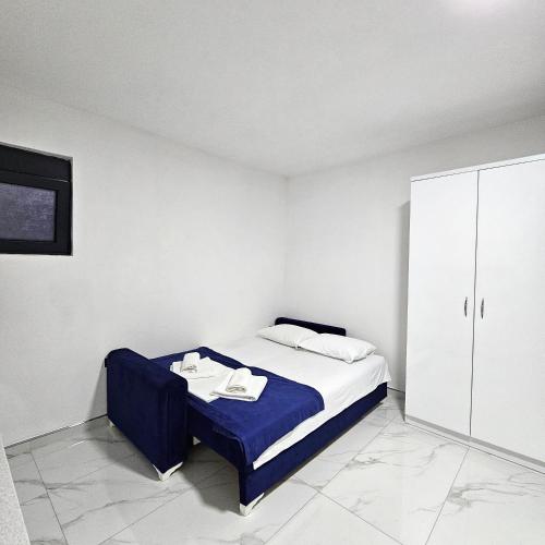 a small bedroom with a bed and a cabinet at Nejla Apartmani Stoj in Ulcinj