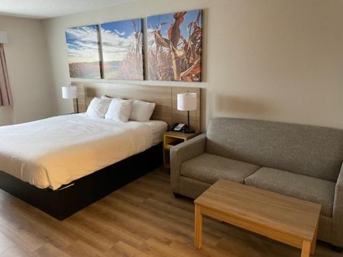 een hotelkamer met een bed en een bank bij Days Inn by Wyndham Ames in Ames