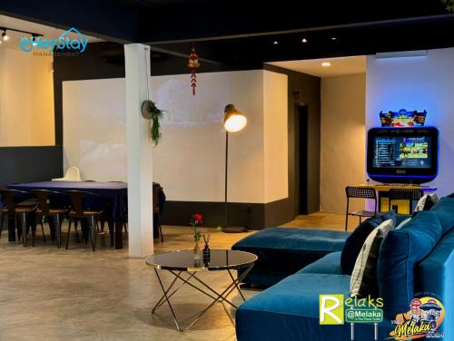 a living room with a couch and a tv and a table at Modern Cave Guest House Walking Distance 5Mins To Jonker in Melaka