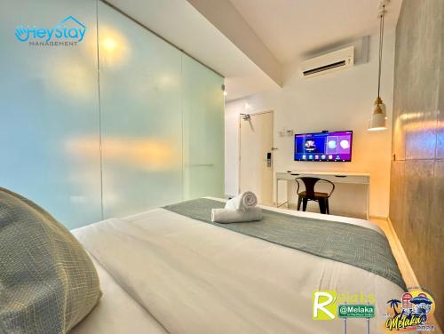 a bedroom with a bed and a desk with a tv at Modern Cave Guest House Walking Distance 5Mins To Jonker in Melaka