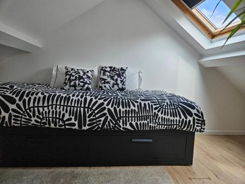 a bedroom with a black and white bed with a window at spacieux duplex Stade de France 24 pour 4 personnes in Saint-Denis