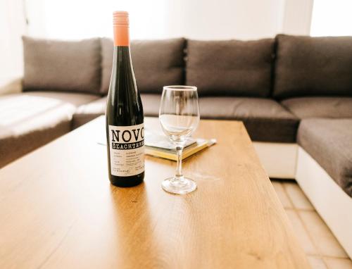 a bottle of wine and a glass on a table at Castle Village Apartment in Krásnohorské Podhradie