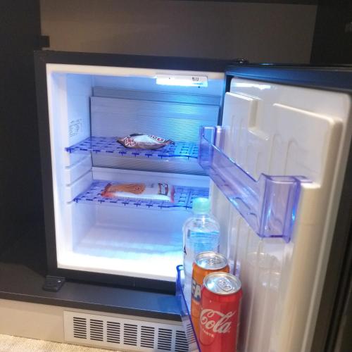 an open refrigerator with a bottle of water and a soda at Ferhadija 31 Old town Sarajevo in Sarajevo