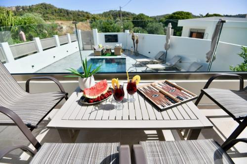 a table with fruit and drinks on a balcony at Melia Casa in Rhodes Town
