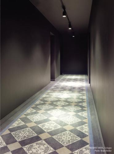 an empty hallway with a tiled floor and a wall at THE QVEST hideaway in Cologne