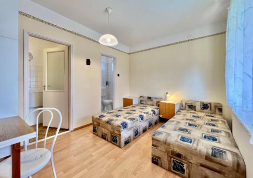 a room with three beds and a table at Muskatli in Zalakaros