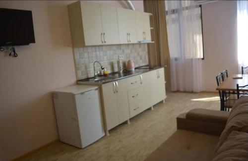 a kitchen with a sink and white cabinets in a room at Апартаменты с кухней и номера с удобствами у моря in K'obulet'i