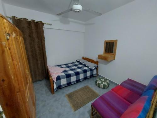 a bedroom with a bed and a couch in it at Anglo Chalets - Ageeba beach in Marsa Matruh