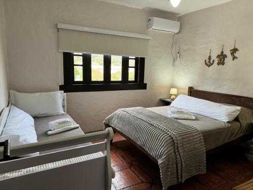 a bedroom with two beds and a window at Bombinhas in Bombinhas