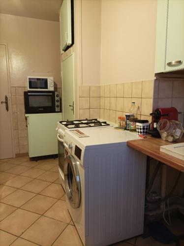 une cuisine avec une cuisinière et une machine à laver dans l'établissement Joli appartement entier, à Vitry-sur-Seine