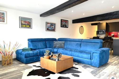- un canapé bleu dans un salon avec une cuisine dans l'établissement l'Olympe - Babyfoot - Cinéma - Parking, à Rouen