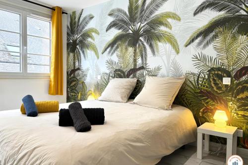- une chambre avec un grand lit blanc et des palmiers sur le mur dans l'établissement l'Olympe - Babyfoot - Cinéma - Parking, à Rouen
