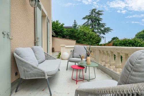 un patio avec des chaises et une table sur un balcon dans l'établissement Maison Bérangère - Welkeys, à Écully