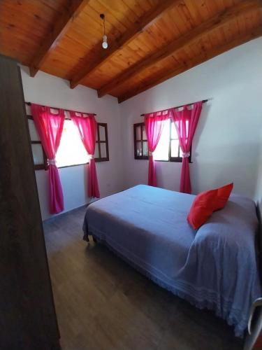 a bedroom with a large bed with red curtains at Barranca de la Luna in Tafí del Valle