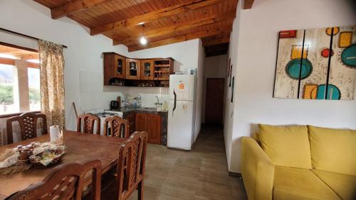 a kitchen and dining room with a table and a refrigerator at Barranca de la Luna in Tafí del Valle