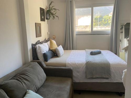 a bedroom with a bed and a couch at Laguna Hostel in Rio de Janeiro