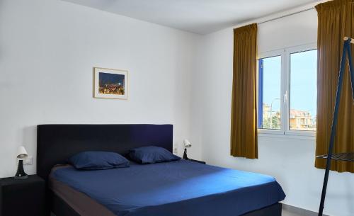 a bedroom with a blue bed and a window at Casa Branca Beach in Santa Maria