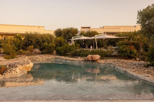 a pool of water in a yard with a building at Masseria San Francesco in Savelletri di Fasano