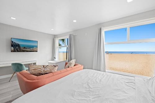 a bedroom with a bed and a couch and a window at 1628 West Oceanfront Oasis 8 in Newport Beach