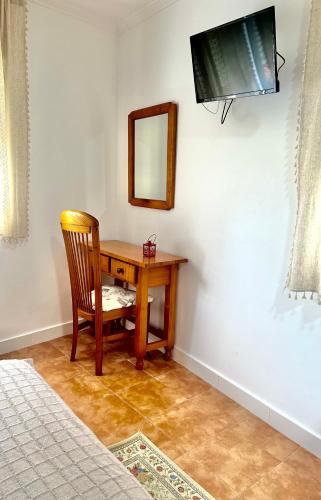 a bedroom with a desk and a mirror and a chair at A Casa de Santos in Combarro